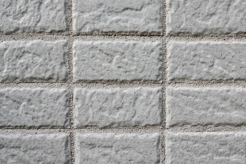 新築の外壁に規則的に並ぶグレーのタイル壁