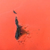 塗装が剥がれて黒く変色した外壁のテクスチャの写真