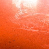 赤い塗装に傷が目立つ壁のテクスチャの写真