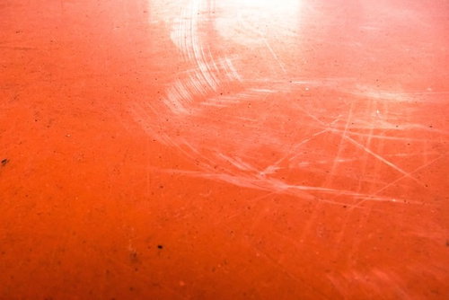 赤い塗装に傷が目立つ壁のテクスチャ