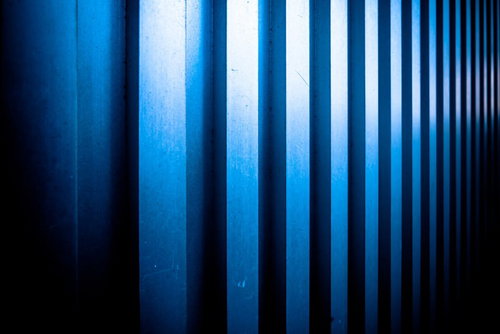 凹凸のあるメタルの壁に映る青い光と影