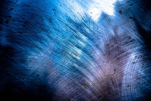 青い光が反射するスクラッチメタル、工業用金属テクスチャ