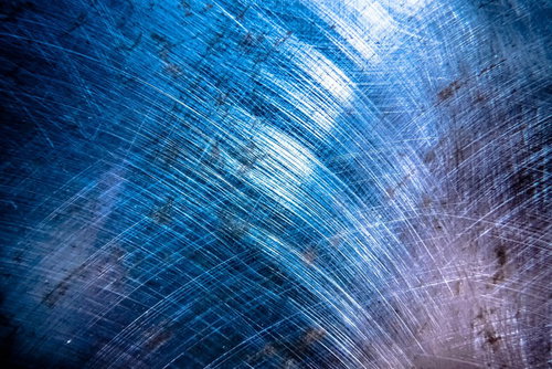 傷とスクラッチが刻まれた青みがかったメタルのテクスチャ