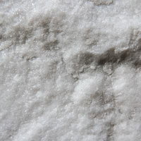 ざらついた結晶の粗い表面。白とグレーの鉱物テクスチャの写真