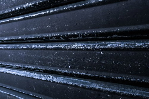 黒いシャッターが閉まる店舗の夕暮れ時の街並み風景