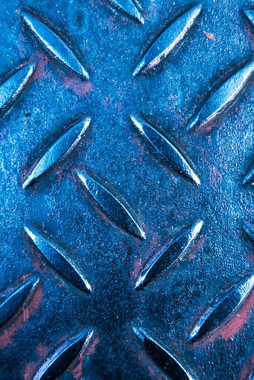 青いメタルの足場板に施されたすべり止めの凹凸加工