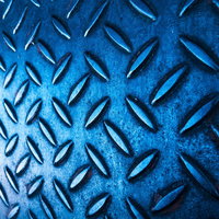 光が差し込む青いメタル足場、ダイヤモンドパターンの滑り止め加工の写真
