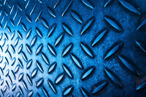 光が差し込む青いメタル足場、ダイヤモンドパターンの滑り止め加工