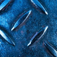 青白い金属製の足場板に施された滑り止め加工の写真