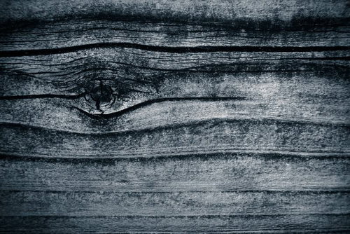 グレーの古い木材に浮かぶ木目の節（テクスチャ）