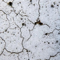 白いペイントが剥がれた老朽化でヒビが入る壁のテクスチャの写真