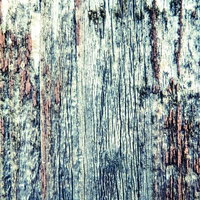 青みがかった色合いの朽ちた木の壁板の写真