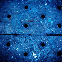 青い金属製の足場板に規則的に穴があいたテクスチャーの写真