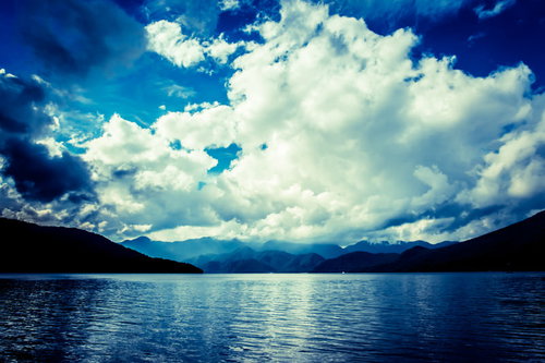 中禅寺湖の夏の晴れた日の湖面と山々の風景の写真