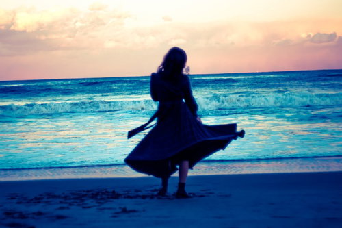 傷心の海辺でかすみ草を持つ女性