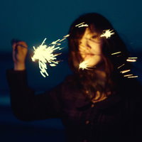 暗闇で手持ち花火を灯す失恋の女性の写真