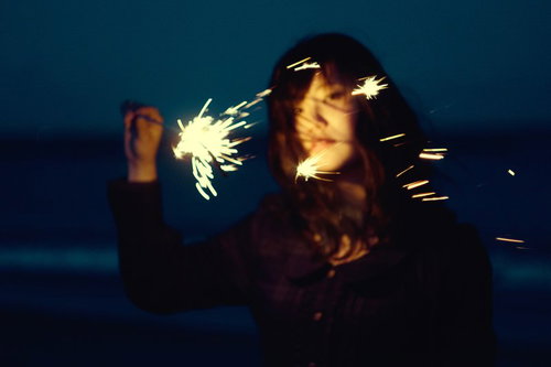 暗闇で手持ち花火を灯す失恋の女性