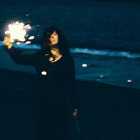 思い出にさようなら、暗闇で手持ち花火を持つ女性の写真