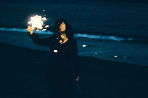 思い出にさようなら、暗闇で手持ち花火を持つ女性
