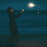暗闇で手持ち花火をする女性の写真