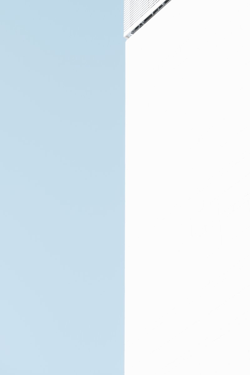 青空を背景にした白い外壁のシンプルな構図