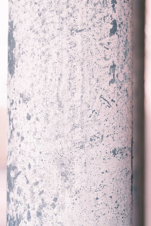 白く塗装された配管の剥げた箇所と下地の金属