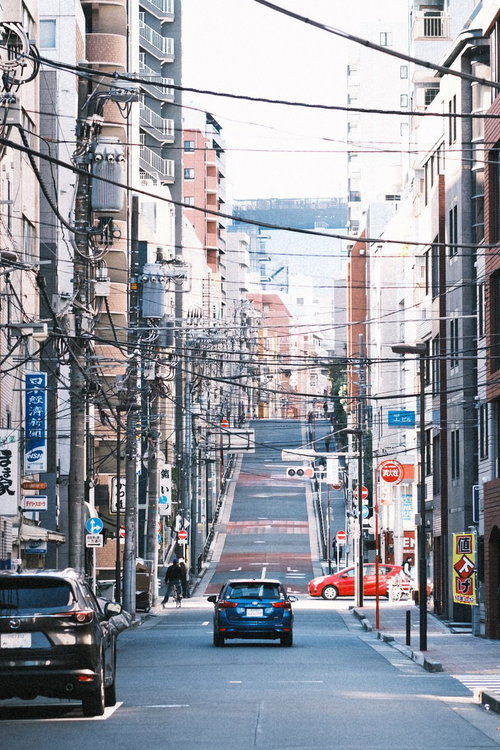 右へ左へ張り巡る電線と車道の都市風景