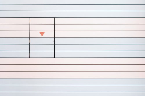 パステルカラーの壁に白い扉と矢印マークの非常口