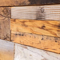 濃い茶色と白木の足場板で作られた壁面のテクスチャーの写真