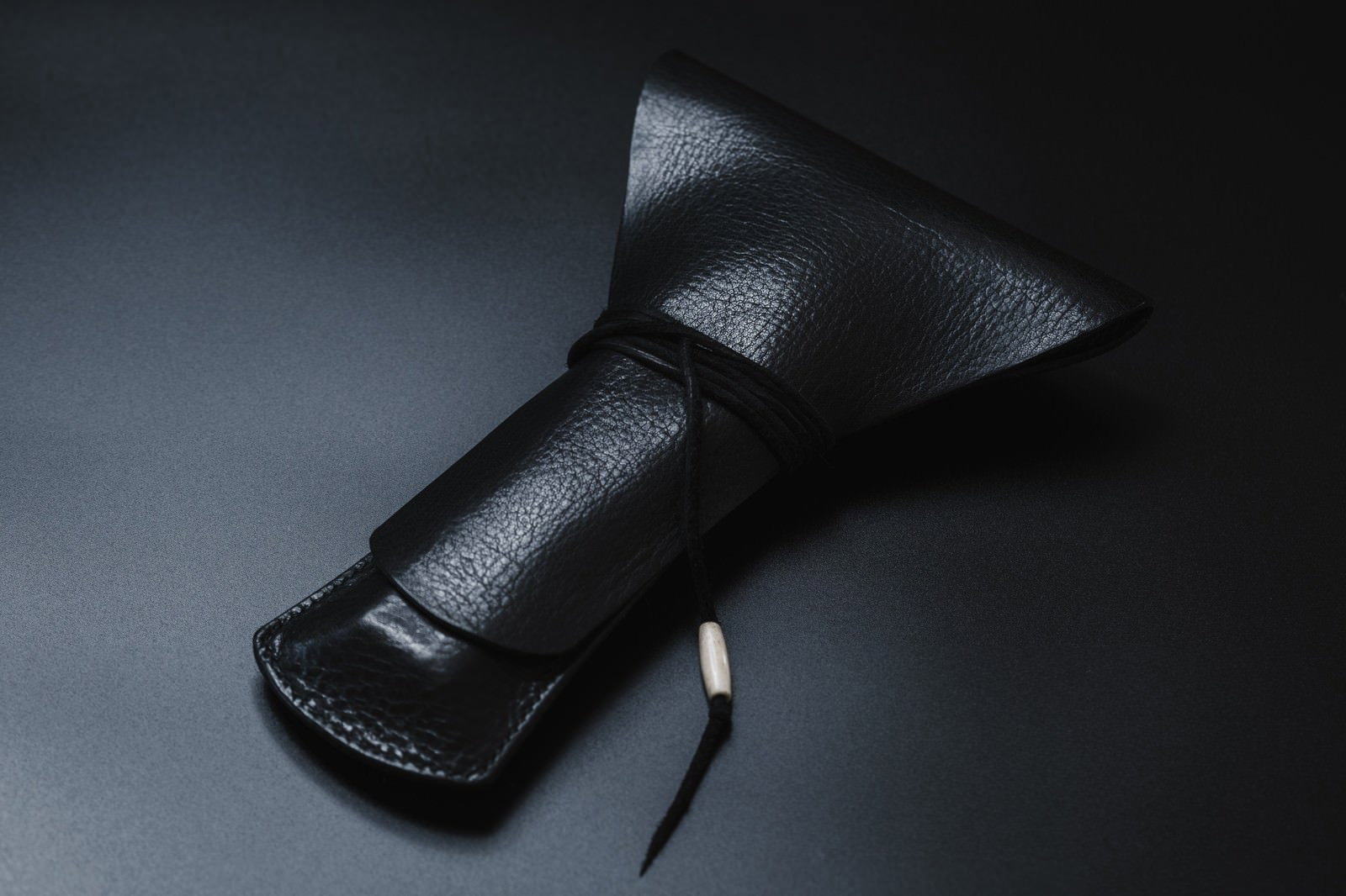 黒い革製の三味線の撥入れケースが置かれている様子