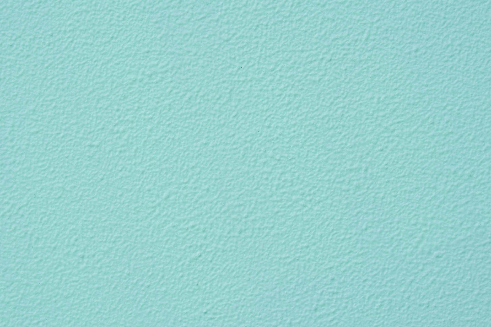 淡いミントグリーンに塗装された滑らかな外壁のテクスチャー