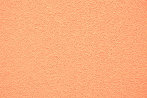 淡いオレンジ色に塗装した外壁のテクスチャー
