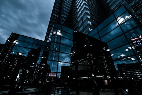 都会のビル群に映り込む光景とオフィスビルの夜景