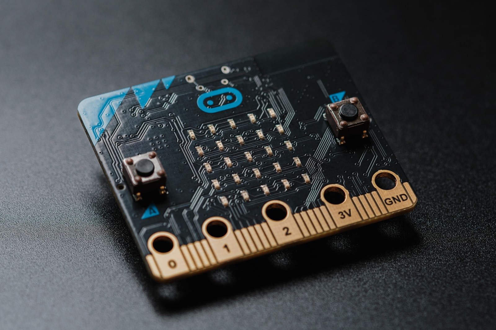 青いLEDディスプレイと金色の端子を持つmicro bitマイコンボード
