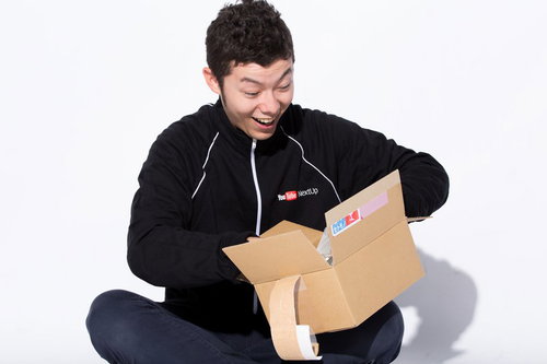 欲しいものリストの商品が届いた時にダンボール箱を開封して喜ぶ男性