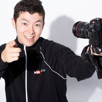 一眼レフカメラで自撮りするYouTuber男性の写真