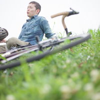 休日のツーリングを楽しむ自転車男子とヘルメットの写真