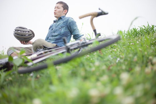 休日のツーリングを楽しむ自転車男子とヘルメット
