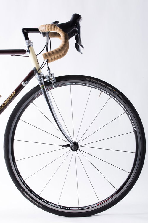 ロードバイクの黒いホイールと茶色いドロップハンドル（前輪）
