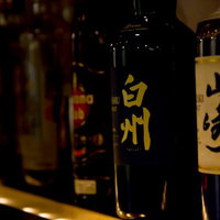 バーの棚に並ぶボトルキープされたお酒の写真