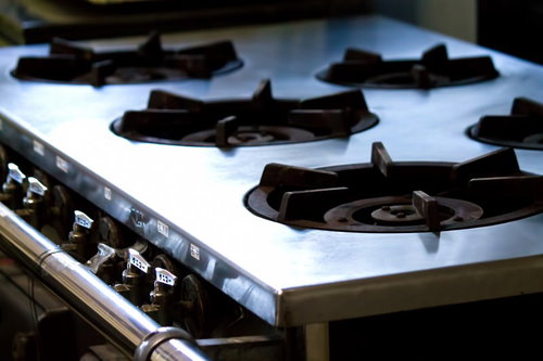 ステンレスの五徳が並ぶ業務用ガス台