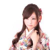 赤い髪飾りと花柄帯の和装姿の若い女性のポートレートの写真