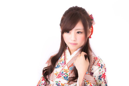赤い髪飾りと花柄帯の和装姿の若い女性のポートレート