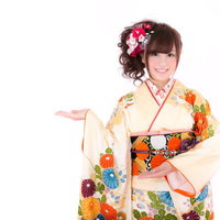 こちらと案内する振袖姿の女性、笑顔で正月や成人式のお知らせに最適の写真