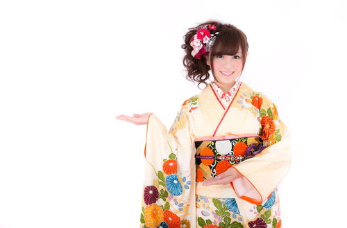 こちらと案内する振袖姿の女性、笑顔で正月や成人式のお知らせに最適の写真