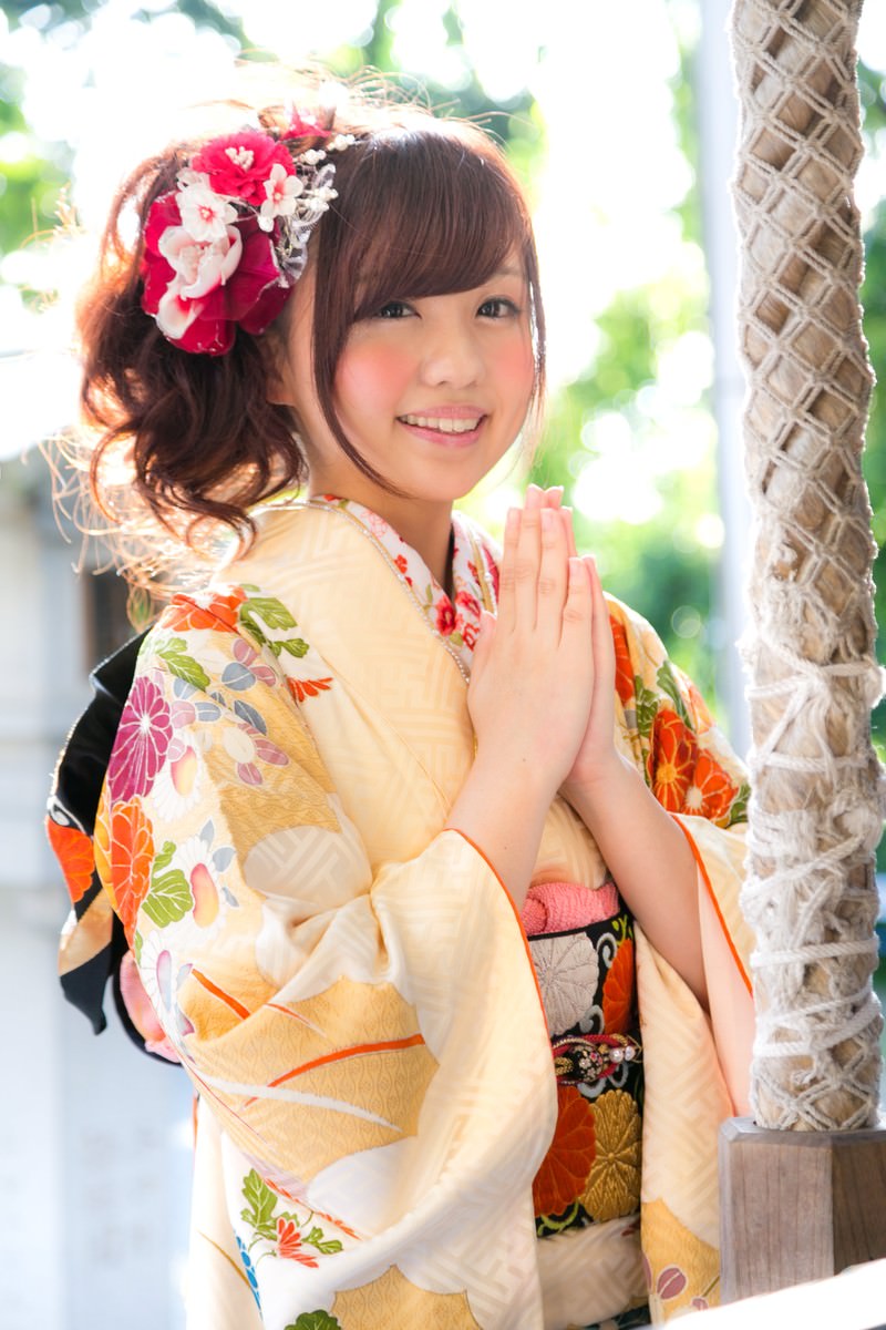 初詣で両手を合わせて祈る振袖姿の女性［モデル：河村友歌］
