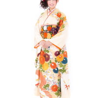 花柄の白い振袖を着た若い女性、赤とピンクの髪飾りで成人式の晴れ着姿の写真