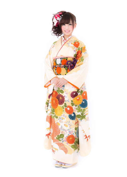 花柄の白い振袖を着た若い女性、赤とピンクの髪飾りで成人式の晴れ着姿の写真