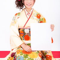 謹賀新年！抱負をホワイトボードに掲げる振袖姿の女性の写真