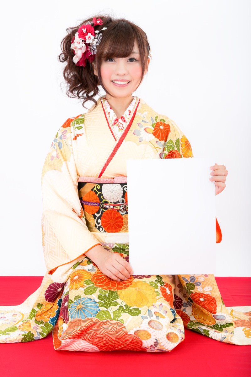 振袖姿でホワイトボードを持ち笑顔の女性が新年の抱負を掲げている［モデル：河村友歌］